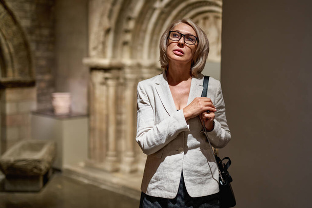 Olgun kadın antika müzesini ziyaret ediyor. - Fotoğraf, Görsel