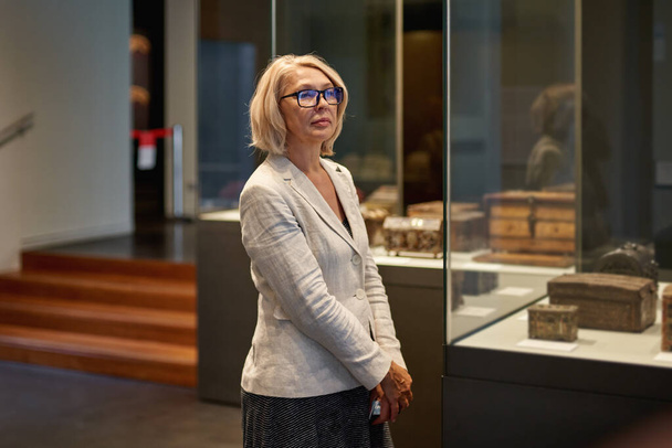 Kobieta zwiedzająca średniowieczne ekspozycje w muzeum - Zdjęcie, obraz