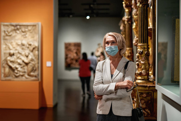 Frau mit Antivirus-Maske im Museum - Foto, Bild