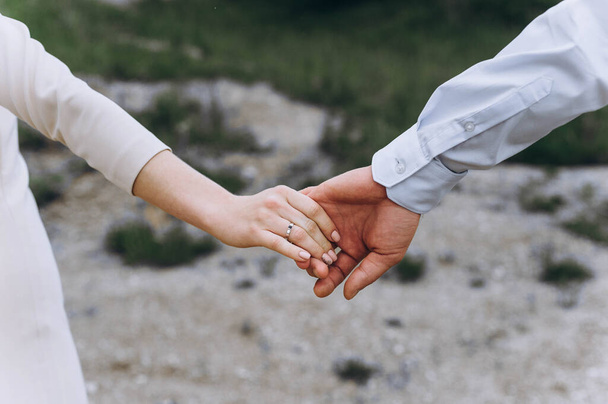 Close up of wedding couple holding hands outdoors. Blurred background. - Foto, imagen
