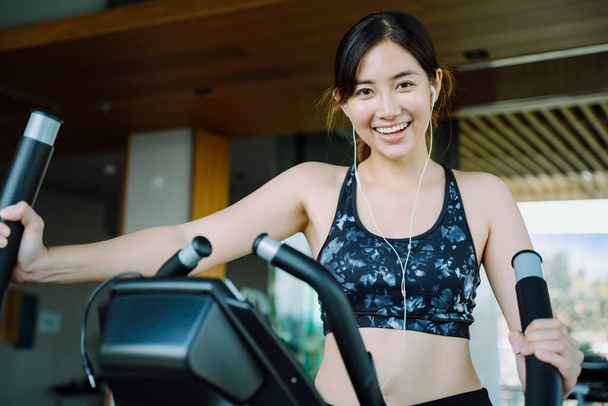 Happy beautiful healthy woman exercising on gym bike indoors. - Fotografie, Obrázek