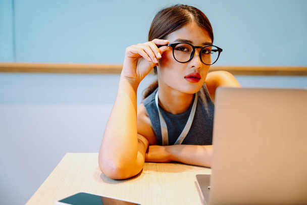 Asijské obchodní žena nosit brýle sedí před počítačem notebook. - Fotografie, Obrázek