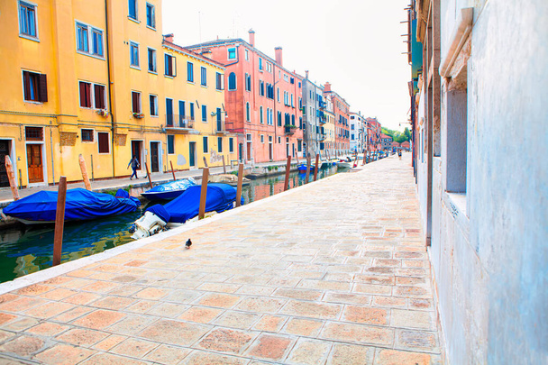 Улица и водный канал с лодками на Венеции. Тротуар в Венеции  - Фото, изображение