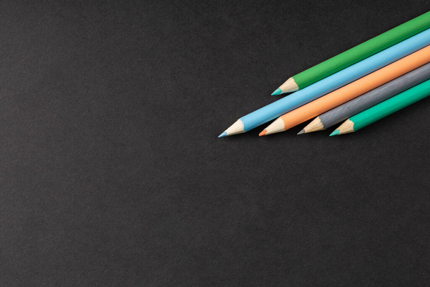 színes ceruzák sorban egy fekete háttér - Fotó, kép