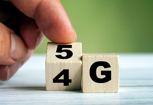 Human hand turn wooden block and change technology word 4G to 5G. Network future. High speed of mobile internet  - Foto, immagini