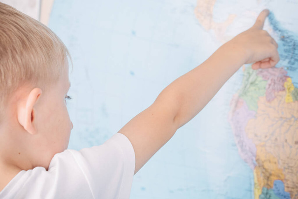 маленький хлопчик на фоні карти світу
 - Фото, зображення