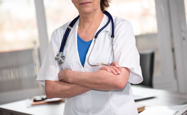 Médica com braços cruzados em consultório médico - Foto, Imagem
