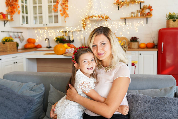 felice famiglia madre e bambina seduta sul divano di casa in autunno - Foto, immagini