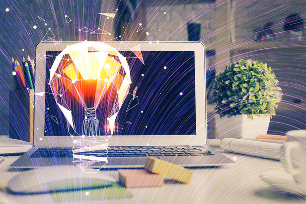 Computer on desktop in office with bulb icon hologram. Double exposure. Concept of idea. - Фото, зображення