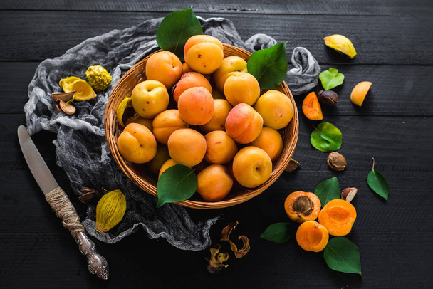 Sweet ripe apricots on black wooden background. Copy space - Fotografie, Obrázek