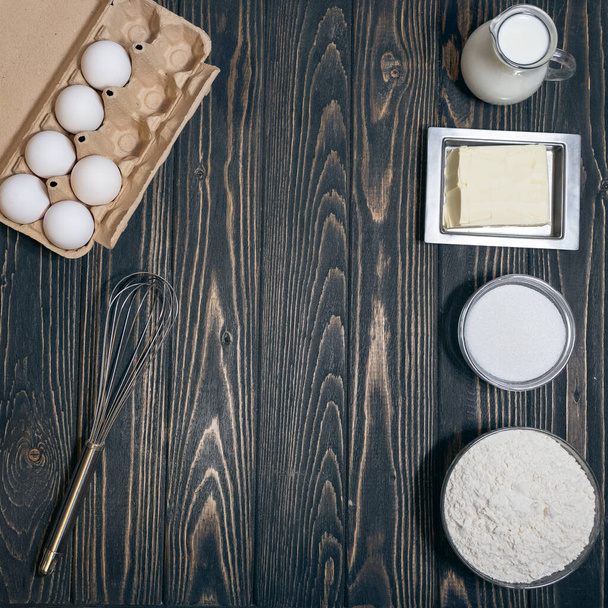 vista superior de farinha, eegs, leite e açúcar na mesa na cozinha - Foto, Imagem