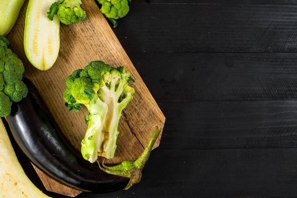 Ripe broccoli, eggplant and zucchini on wooden background. Copy space - Zdjęcie, obraz