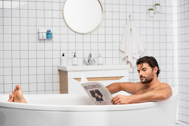 Homme barbu avec des lettres d'affaires sur le journal prendre un bain à la maison  - Photo, image