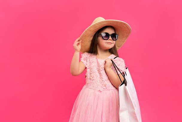 Girl with many shopping bags in dress on pink backgound. - Foto, Bild