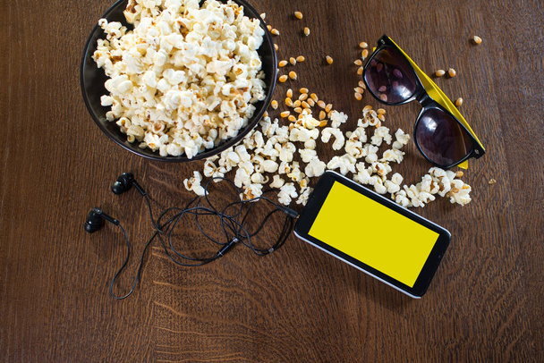 Electronic device smartphone on the popcorn background. Copy space - Zdjęcie, obraz