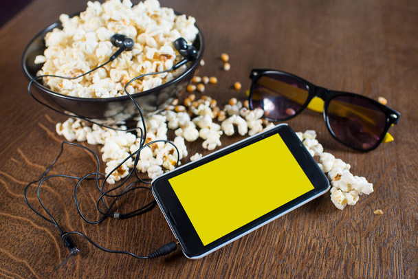 Electronic device smartphone on the popcorn background. Copy space - Foto, Imagem