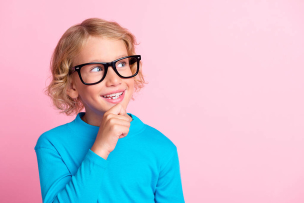 Photo of little boy hand chin interested look up empty space wear spectacles blue turtleneck isolated pastel pink color background - Fotografie, Obrázek