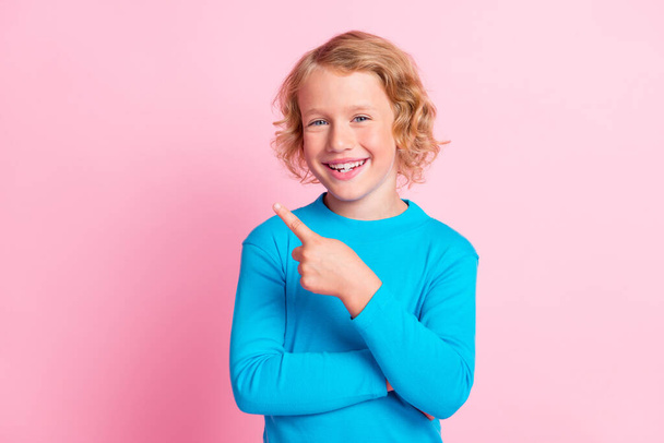 Photo of little boy indicate finger empty space wear blue turtleneck isolated pastel pink color background - Fotó, kép