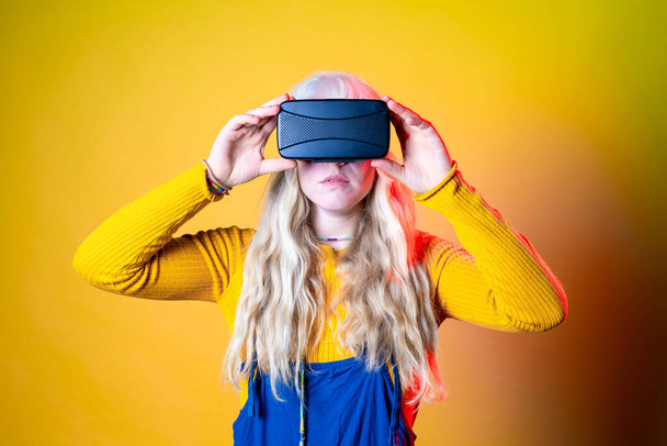 Caucasian woman on green background using vr glasses - Isolated caucasian young woman wearing futuristic headset - entertainment, technology, futuristic concept - Photo, Image