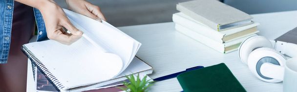 cropped view of woman turning pages of notebook, horizontal banner - Foto, Imagen