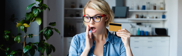 shocked blonde woman in eyeglasses making purchase online, horizontal banner - Foto, Imagen