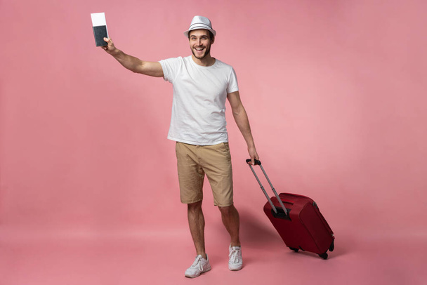 Man traveler with suitcase, passport and ticket on color background. - 写真・画像