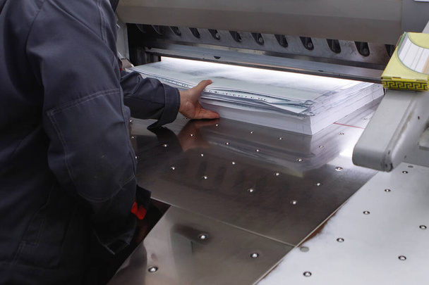 Cutting piles of paper with a guillotine blade in a printing house. - Photo, Image