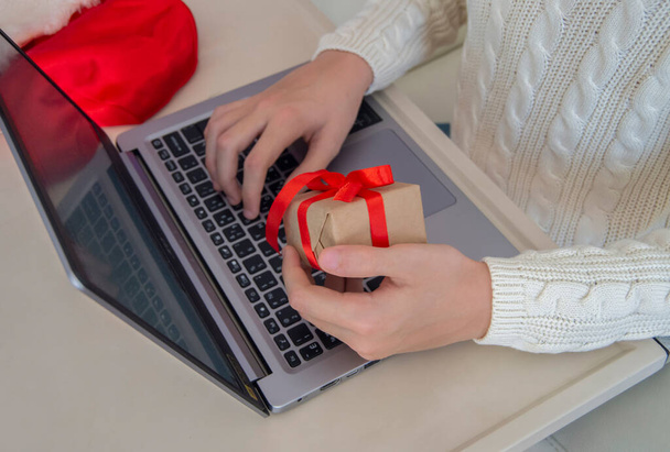 man with a gift works at a laptop in the office - Foto, Imagen