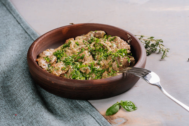 Dish of liver with herbs on the wooden background - Foto, Bild