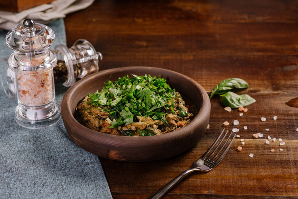 Dish with chopped meat with sauce and herbs on the wooden background - Foto, Imagem