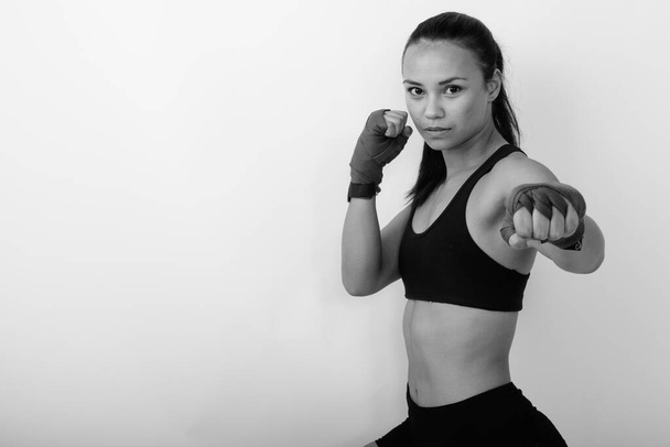 Studio shot de jeune belle femme asiatique comme combattant pour les arts martiaux sur fond blanc en noir et blanc - Photo, image