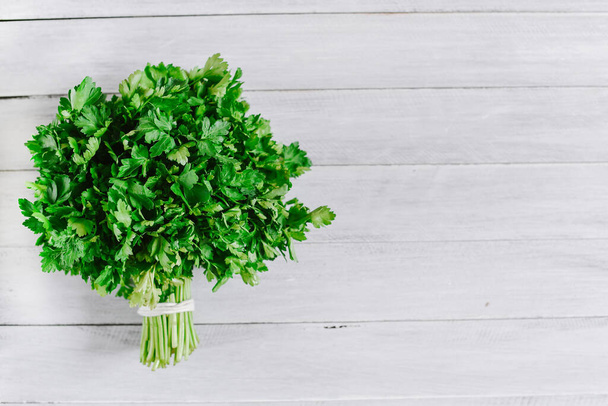 Bunch of fresh parsley on the white background. Top view. Copy space. Flatlay - Zdjęcie, obraz