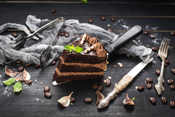 Delicious piece of chocolate cake with layers on the black background - Zdjęcie, obraz