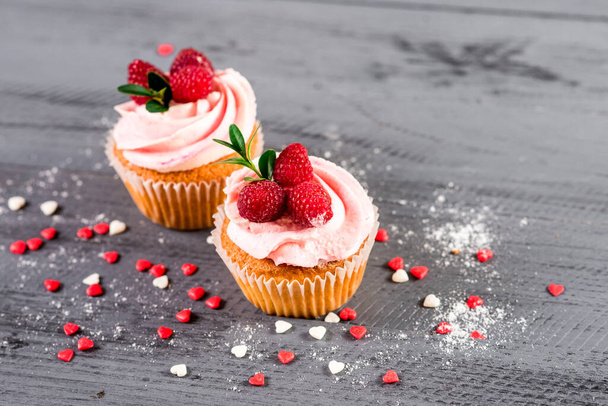 Sweet cupcakes with raspberrie on the wooden background - Фото, зображення