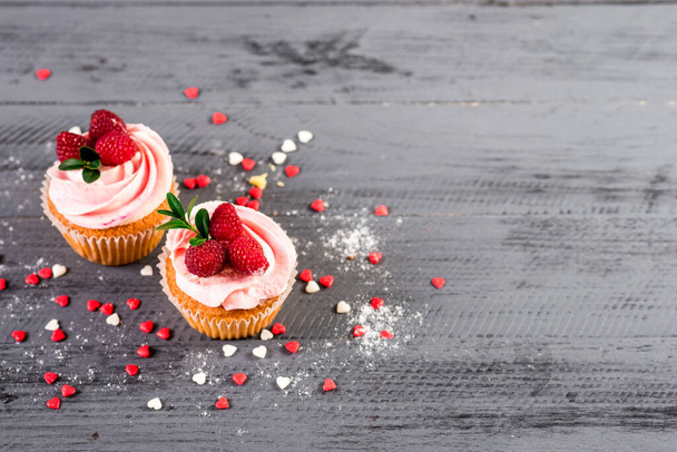 Sweet cupcakes with raspberrie on the wooden background - Фото, зображення