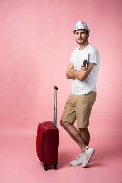 Человек путешественник с чемоданом, паспортом и билетом на цветном фоне. - Фото, изображение