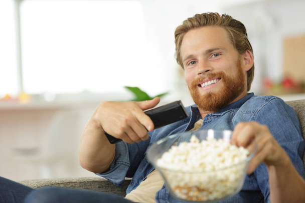 a happy man eating popcorn - Φωτογραφία, εικόνα
