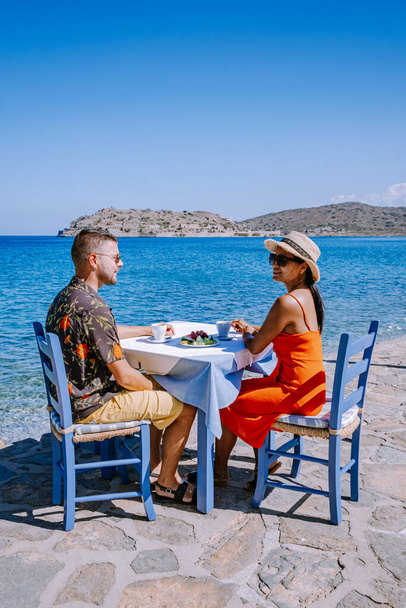 Plaka Lassithi avec table et chaises bleues traditionnelles et la plage en Crète Grèce - Photo, image