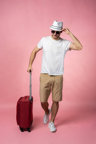Man traveler with suitcase, passport and ticket on color background. - Zdjęcie, obraz