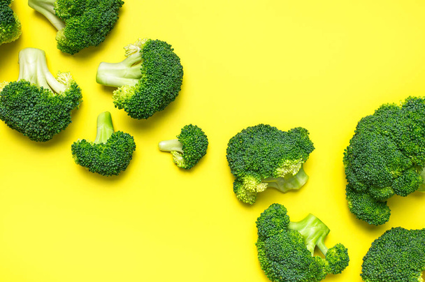 Kreatives Ernährungskonzept. Frischer roher grüner Brokkoli auf gelbem Hintergrund. Gesundes Gemüse, vegane Biokost, Vitamine. Flache Lagekopierfläche von oben. Abstraktes Muster von Brokkoli-Kohl. - Foto, Bild