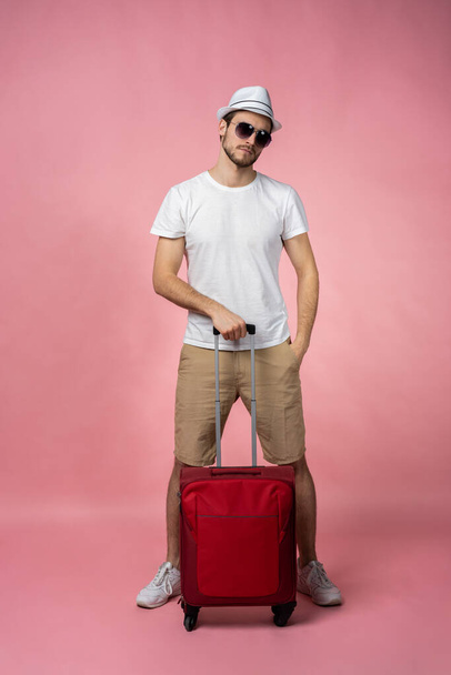 Man traveler with suitcase, passport and ticket on color background. - Foto, Imagen