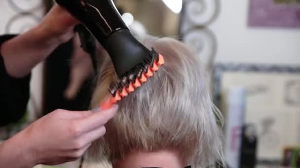 Ηλικιωμένη γυναίκα με κοντά γκρίζα μαλλιά κάνει styling σε ένα σαλόνι ομορφιάς. Βίντεο - Πλάνα, βίντεο