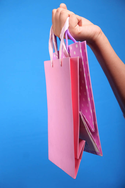 ženy ruční držení nákupní taška na modrém pozadí . - Fotografie, Obrázek