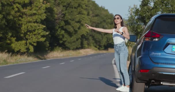 Femme conductrice attrapant l'aide pour sa voiture cassée, accident à la route de campagne vide - Séquence, vidéo