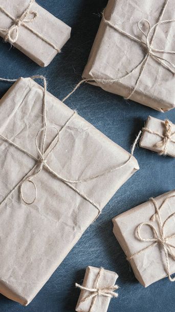 Gifts wrapped in kraft paper on black background - Фото, зображення