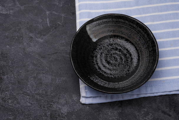 Empty black ceramic plates on a dark black table - top view. - Photo, Image