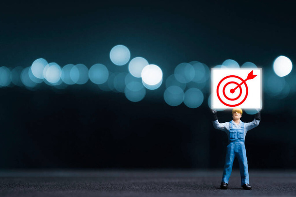 Miniatuur figuur rijzen een bord met rode target board voor focus met objectieve doelgroep business en investeringen. - Foto, afbeelding