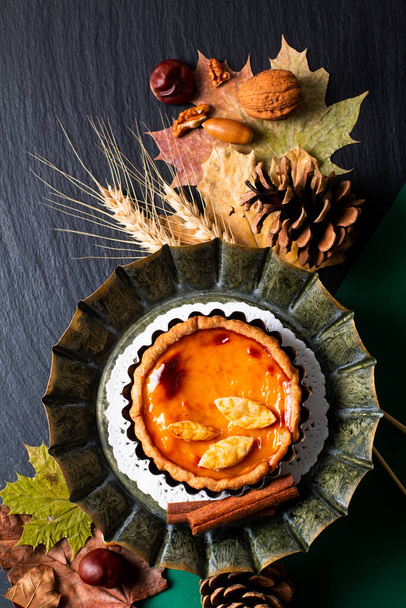 Autumn food concept homemade organic rustic Pumpkins pie decorate by autumn leave on black background with copy space - Photo, Image