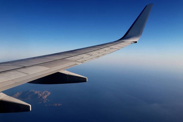 Plane wing over the ocean with islands - Photo, Image