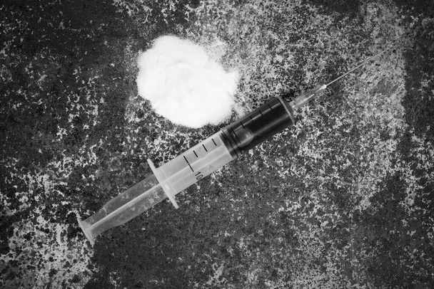Syringe and drugs on dirty rusty background. Injection syringe. addiction. black and white photo - Φωτογραφία, εικόνα